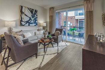 A living room with a grey couch, a brown armchair, and a coffee table